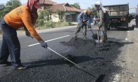 Sejumlah pekerja melakukan perbaikan jalan. ilustrasi