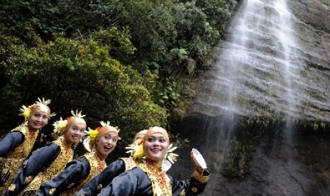 Sejumlah pelajar berlatih tari piring sesaat sebelum tampil pentas di kawasan air terjun Lembah Harau, Lima Puluh Koto, Sumatera Barat, Kamis (9/6). Obyek wisata yang menawarkan panorama alam berupa tebing tinggi, hutan, dan air terjun itu merupakan tempat