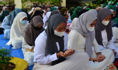 Sejumlah pelajar bersama guru mereka berdoa dan berzikir. 