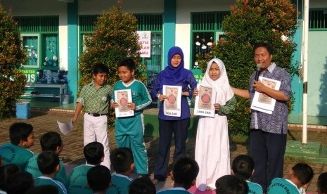 Sejumlah pelajar, guru dan orang tua SD Terpadu Bina Ilmu Parung, Bogor, Jawa Barat, menyerahkan bantuan 41 zak semen dan satu kijang pasir untuk pembangunan ruang guru, ruang kelas baru, dan toilet, Senin, (14/5)