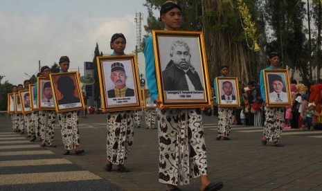 Sejumlah pelajar membawa foto bupati Wonosobo dari waktu ke waktu saat mengikuti kirab budaya dalam rangkaian acara Hari Jadi ke-193 Kabupaten Wonosobo di alun-alun Kota Wonosobo, Jateng, Selasa (24/7).