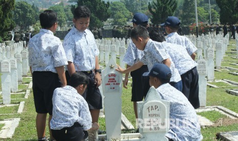 Sejumlah pelajar mengamati nama-nama pahlawan yang dimakamkan pada peringatan Hari Pahlawan, di Taman Makam Pahlawan Cikutra, Kota Bandung, Jumat (10/11).