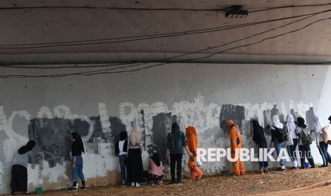 Sejumlah pelajar mengecat tembok yang menjadi sasaran vandalisme saat kericuhan terjadi dalam unjuk rasa di kawasan Senayan, Jakarta, Jumat (4/10/2019).