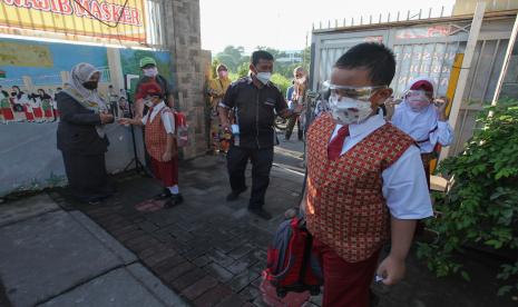 Sejumlah pelajar menjalani tes suhu badan sebelum masuk sekolah di SDN Klampis Ngasem I, Surabaya, Jawa Timur, Senin (10/1/2022). Pemkot Surabaya mulai melaksanakan Pembelajaran Tatap Muka (PTM) 100 persen di tingkat PAUD, TK, SD dan SMP yang digelar dalam dua sesi menyesuaikan kondisi sekolah masing-masing dengan menerapkan protokol kesehatan secara ketat.