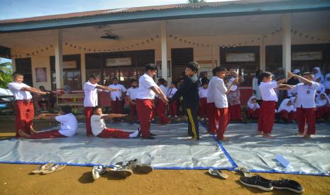 Sejumlah pelajar SD membentuk tulisan gempa saat mengikuti sesi trauma healing oleh Yayasan Qolbun Salim di SDN 21, Kecamatan Pasaman, Nagari Aua Kuniang, Kabupaten Pasaman Barat, Sumatera Barat, Rabu (9/3/2022). Trauma Healing diberikan kepada anak-anak korban gempa Pasaman Barat itu dengan bermain dan mengenal lebih dekat gempa agak mereka tidak takut dan traumanya hilang.