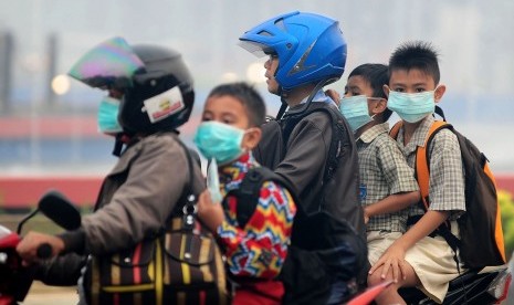  Sejumlah pelajar sekolah dasar menggunakan masker saat melintasi di Jalan Ahmad Yani, Pontianak, Kalimantan Barat, Kamis (10/9).