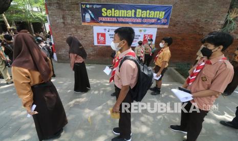 Sejumlah pelajar Sekolah Menengah Pertama (SMP) antre untuk mendapatkan suntikan vaksin COVID-19 di Taman Sekartaji, Kota Kediri, Jawa Timur, Senin (16/8/2021). Pemkot Kediri menggelar vaksinasi COVID-19 dosis pertama secara massal bagi pelajar SMP guna mewujudkan kekebalan kelompok sebagai persiapan pelaksanaan pembelajaran tatap muka.