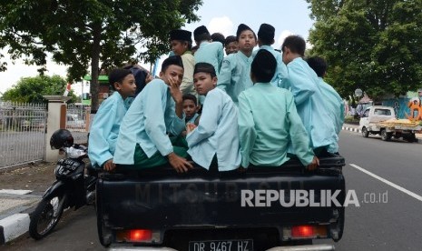 Sejumlah pelajar turun dari mobil bak di depan Kantor Gubernuran untuk menonton MTQ Nasional ke XXVI yang diadakan di Nusa Tenggara Barat, Ahad (31/7