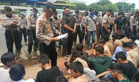 Sejumlah pelajar yang menggelar aksi di depan Kompleks Parlemen RI  diceramahi oleh personel kepolisian. Rabu (25/9). 