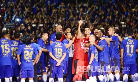 Sejumlah pemain Persib berswafoto dengan latar belakang ribuan bobotoh di sela-sela launcing Pemain Persib 2017, di Stadion Siliwangi Bandung, Ahad (2/4). 