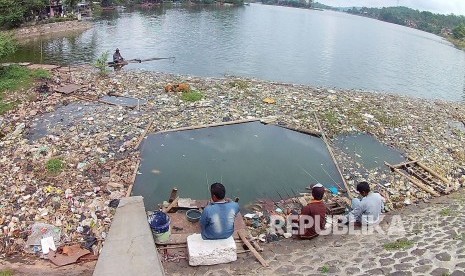 Sejumlah pemancing mengarahkan jorannya ke lubang yang sengaja mereka buat di antara sampah di pinggiran Situ Ciburuy, Padalarang, Kabupaten Bandung Barat, Senin (16/1). 