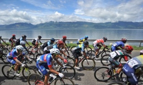 Sejumlah pembalap berpacu pada etape IV Tour de Singkarak 2017, di tepian Danau Singkarak, Tanah Datar, Sumatera Barat, Selasa (21/11). Tersisa 89 pembalap mengikuti etape IV dengan rute Dermaga Singkarak, Kab Solok menuju Payakumbuh sejauh 106,4 kilometer.