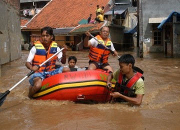 Sejumlah Pemuda dengan perahu karet bersiap - siap menolong warga yang terkena banjir di Jakarta. 