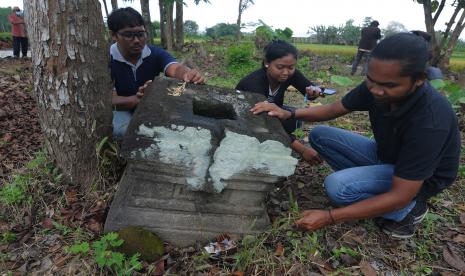 Sejumlah pemuda membersihkan rumput di sekitar batu yoni di situs Candi Nglumbang, Dungik, Soropaten, Karanganom, Klaten, Jawa Tengah, Sabtu (2/4/2022). Kegiatan pemberdayaan warga setempat itu bertujuan untuk menjaga dan merawat bersama situs benda cagar budaya yang memiliki nilai sejarah