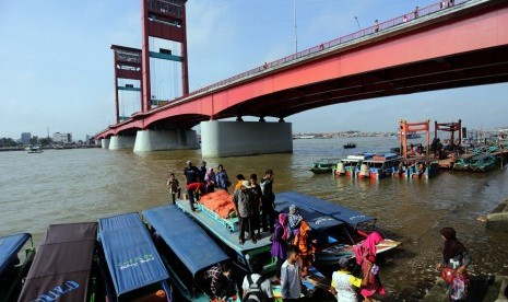 Sejumlah pemudik arus balik pengguna jasa angkutan sungai tiba di dermaga air bawah jembatan Ampera Palembang, Senin (20/7).