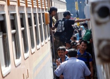 Sejumlah pemudik berebut untuk memasuki rangkaian gerbong kereta api yang akan membawa kekampung halaman di Stasiun Pasar Turi, Surabaya, Senin (29/8).