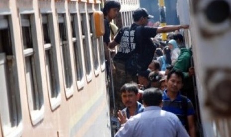 Sejumlah pemudik berebut untuk memasuki rangkaian gerbong kereta api yang akan membawa kekampung halaman di Stasiun Pasar Turi, Surabaya, Senin (29/8).