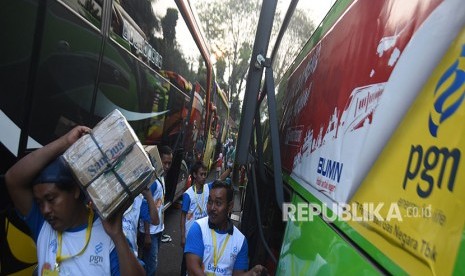 Sejumlah pemudik memasukkan barang bawaan mereka ke bagasi sebelum diberangkatkan pada program Mudik Bareng PGN 2018 di Balai Komando Kopassus, Jakarta Timur, Jumat, (8/6). 