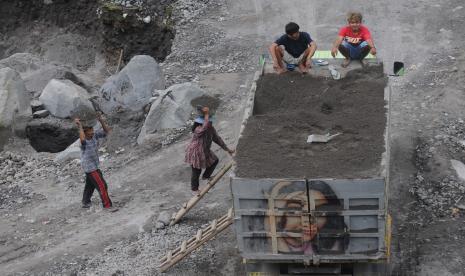 Sejumlah penambang memindahkan pasir secara manual ke truk pengangkut di Kali Woro, Kemalang, Klaten, Jawa Tengah, Jumat (25/6/2021). Pascaterjadinya awan panas guguran Gunung Merapi ke arah tenggara, aktivitas penambang pasir manual di Kali Woro tersebut masih berjalan dengan normal.