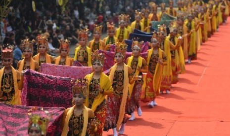 Sejumlah penari gandrung memegangi gaun Ratu Seblang saat tampil dalam Banyuwangi Ethno Carnival (BEC) di Banyuwangi, Jawa Timur, Sabtu (22/11). Acara ini merupakan bagian dari Festival Banyuwangi.