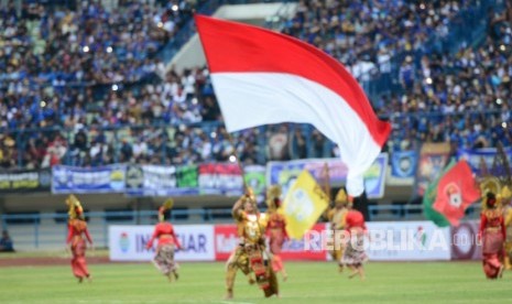 Sejumlah penari mengibarkan bendera Merah Putih dan bendera klub pada seremoni pembukaan Piala Presiden 2018 di Stadion Gelora Bandung Lautan Api, Bandung, Jawa Barat, Selasa (16/1). 