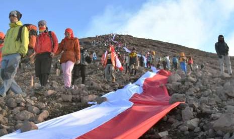 Sejumlah pendaki membentangkan bendera merah putih di lereng Gunung Kerinci, Jambi, Jumat (17/8).