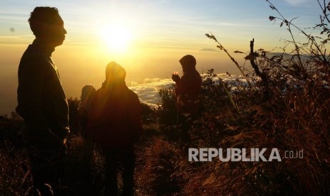 Sejumlah pendaki menikmati matahari terbit di Sendang Drajat kawasan Puncak Gunung Lawu, Perbatasan Jawa Tengah dan Jawa Timur, Jumat (19/8).