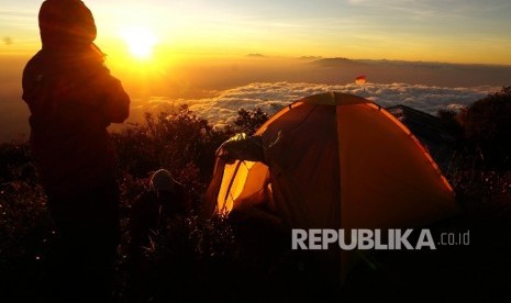 Sejumlah pendaki menikmati matahari terbit di Sendang Drajat kawasan Puncak Gunung Lawu, Perbatasan Jawa Tengah dan Jawa Timur, Jumat (19/8).