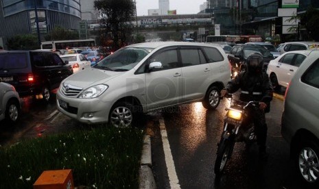   Sejumlah pengemudi kendaraan terpaksa memutar balik melewati jalur hijau saat terjebak kemacetan di Jalan MH. Thamrin, Jakarta, Jumat (21/12).   (Republika/Yasin Habibi)