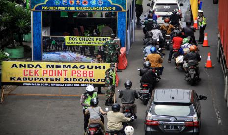 Sejumlah pengendara di cek point petugas yang akan masuk ke Sidoarjo di Pos Polantas Waru, Sidoarjo, Jawa Timur, Selasa (28/4/2020). Petugas gabungan memperketat akses masuk ke Sidoarjo dengan melakukan screening atau pemeriksaan kepada warga di hari pertama pelaksanaan Pembatasan Sosial Berskala Besar (PSBB) di Sidoarjo.