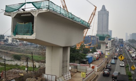 Sejumlah pengendara kendaraan bermotor melintasi lokasi pembangunan jalur kereta ringan atau Light Rail Transit (LRT) Jabodebek rute Cawang-Dukuh Atas di Cawang, Jakarta, Rabu (10/4/2019).