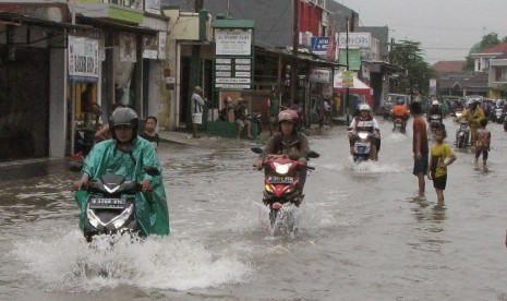 Sejumlah pengendara kendaraan bermotor mengarungi banjir di ruas jalan Nusantara Raya, Perumnas 3, Bekasi Timur, Jawa Barat, Jumat (26/2).