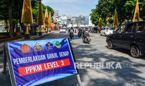 Sejumlah pengendara melintas di dekat papan informasi pemberlakukan aturan ganjil-genap di Jalan KHZ Mustofa, Kota Tasikmalaya, Kamis (5/8/2021). Satgas Penanganan COVID-19 Kota Tasikmalaya memberlakukan aturan ganjil genap di wilayah pusat kota untuk mengurangi mobilitas kendaraan selama PPKM Level 3.