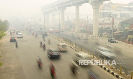 Sejumlah pengendara melintas di Jalan Jenderal Sudirman Palembang yang diselimuti kabut asap di Palembang, Sumatera Selatan, Selasa (15/10/2019).