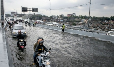 Sejumlah pengendara melintasi genangan banjir di Jembatan Layang Pasopati Bandung, Jawa Barat, Jumat (29/9). 