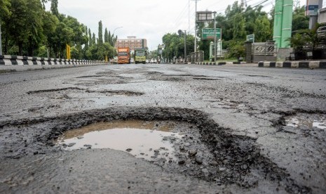 Sejumlah pengendara melintasi jalan yang berlubang di jalur pantura, Pekalongan, Jawa Tengah, Selasa (29/1/2019). 