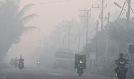 Sejumlah pengendara menembus kabut asap yang menutupi kawasan jalan Nasional Medan-Banda Aceh di Desa Suak Raya, Johan Pahlawan, Aceh Barat, Aceh, Senin (23/10). Kebakaran lahan gambut di enam Kecamatan di kabupaten setempat menyebabkan sejumlah wilayah diselimuti kabut asap dengan jarak pandang menjadi hanya 30-100 meter.