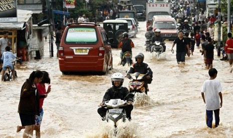 Sejumlah pengendara menerabas banjir yang memutus jalan Raya Jati Kramat, Jatiasih, Bekasi, Jawa Barat, Rabu (17/4). Meluapnya air Kali Bekasi menyebabkan terputusnya Jalan Raya Jati Kramat di sekitar perumahan Bumi Nasio Indah.