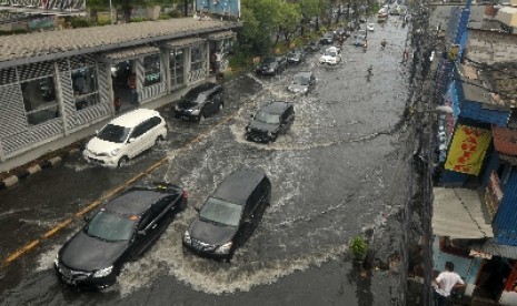 Sejumlah pengendara menerobos genangan air di Jalan Gunung Sahari, Jakarta, Ahad (18/11).