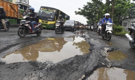 Sejumlah pengendara menghindari jalan yang rusak di wilayah Kraton, Kabupaten Pasuruan, Jawa Timur, Senin (16/1).