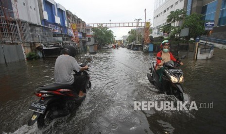 Sejumlah pengendara menorobos genangan air saat banjir melanda kawasan Jalan Brigjen Katamso, Banjarmasin, Kalimantan Selatan, Selasa (31/12/2019).