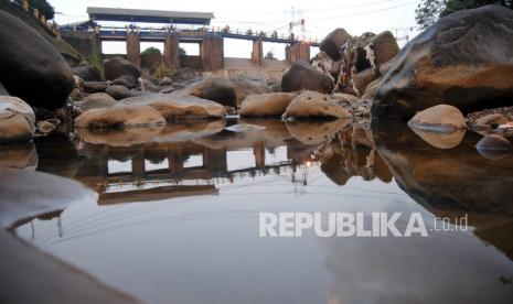 Sejumlah pengendara motor melintas di jembatan Bendung Katulampa, Kota Bogor, Jawa Barat, Rabu (28/7/2021). Memasuki musim kemarau, debit air di Bendung Katulampa, Bogor menyusut hingga 0 cm dari normal 40 ribu liter per detik menjadi 4000 liter per detik sehingga pasokan air untuk saluran irigasi pertanian ke wilayah Jakarta, Bogor dan Depok kapasitasnya berkurang.