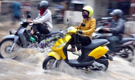  Sejumlah pengendara motor melintas diatas jalur yang terendam banjir di Kampung Keramat, Condet, Jakarta Timur, Senin (8/10).   (Rakhmawaty La'lang)