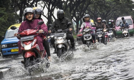 Sejumlah pengendara motor melintasi banjir di ruas Jalan Soekarno Hatta, Gedebage, Kota Bandung, Rabu (25/12).