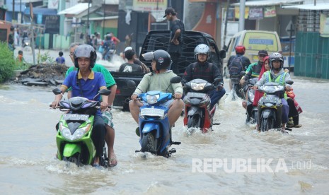 Sejumlah pengendara motor melintasi jalan yang sudah terendam banjir luapan Sungai Citarum di Jalan Banjaran, kecamatan Baleendah, Kabupaten Bandung, Rabu (15/11).