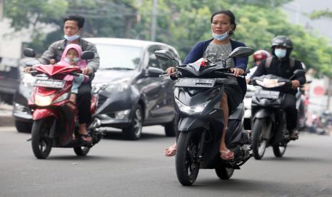 Sejumlah pengendara motor memakai sandal jepit melintas di Jalan Raya Ciledug, Kreo, Tangerang, Banten, Selasa (14/6/2022). Korlantas Polri resmi melarang pengendara sepeda motor menggunakan sandal jepit untuk meminimalkan risiko yang dialami pengendara motor apabila terjadi kecelakaan. 