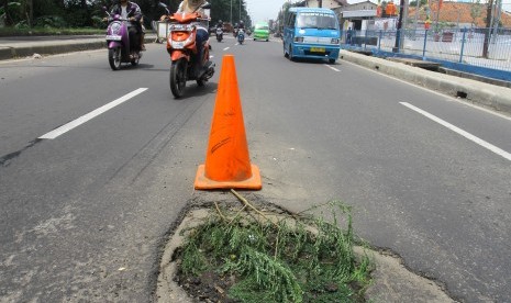 Sejumlah pengendara saat melintasi jalan yang berlubang di Jalan Raya Bogor, Nanggewer, Kabupaten Bogor, Jawa Barat, Rabu (23/3).