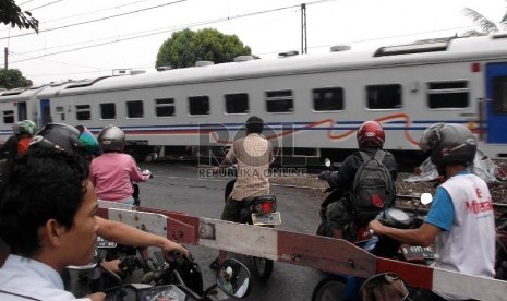  Sejumlah pengendara sepeda motor menerobos pintu palang perlintasan kereta api.