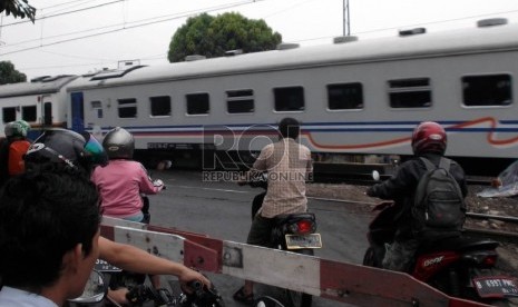 Sejumlah pengendara sepeda motor menerobos pintu palang perlintasan kereta api di Tanah Tinggi Jakarta, Rabu (9/12).