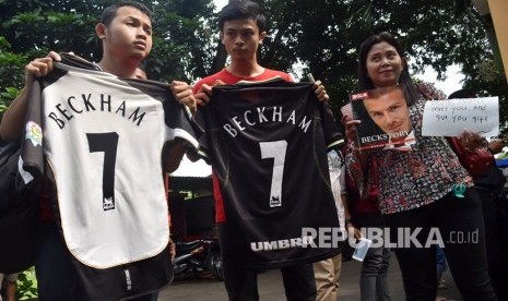 Sejumlah penggemar mantan pesepakbola asal Inggris, David Beckham membentangkan kaos sepakbola dan poster saat menanti idolanya keluar usai mengisi acara di SMP 33 Semarang, Jawa Tengah, Rabu (28/3). 